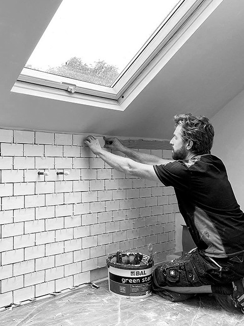 Martin Tood tiling a bathroom wall